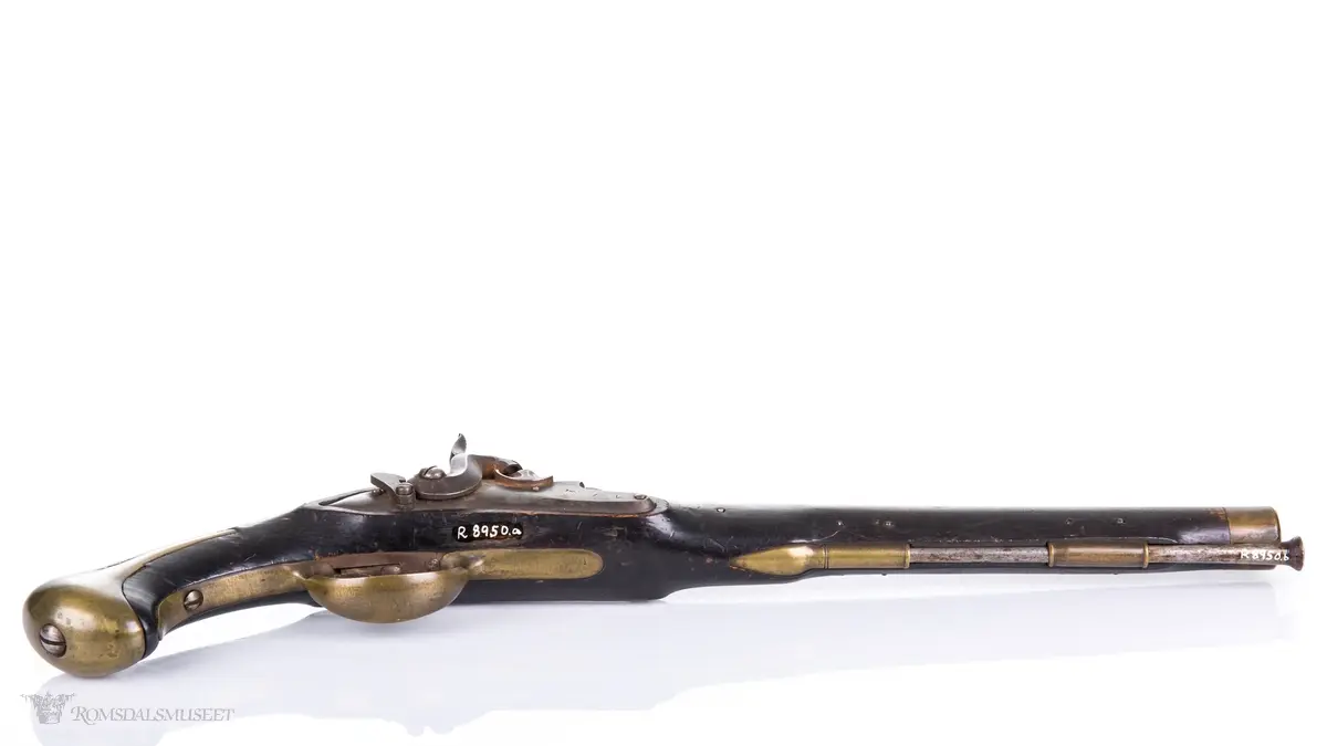 Flintlåspistol med glattboret løp, uten baksikte og med åpent korn. Skjefte av bøk med messingbeslag i enden og ved munningen. To røkner med ladestokk.