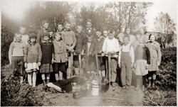 Gruppebilde av barn og ungdommer, tatt utendørs. Kaffekjeler