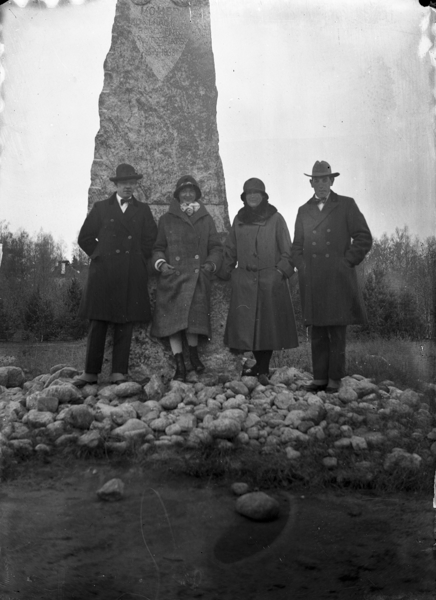 Fyra personer vid Mohed regementes monument (sten).