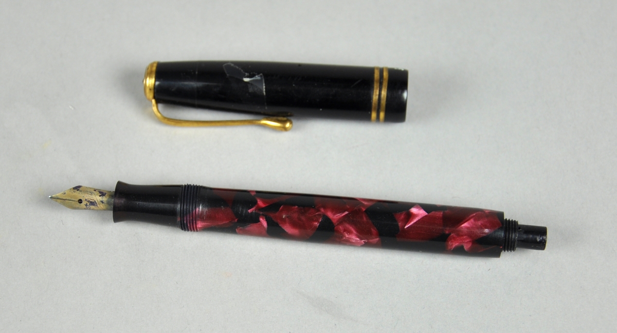 Fyllepenn med hylse og pennesplitt. Pennen kan åpnes bakerst for etterfylling av blekk, men tuppen mangler.