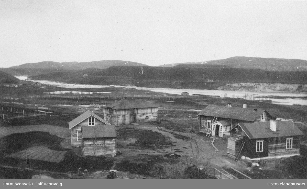 Handelsmann A. Wartiainens gård i Neiden, 1905. I bakgrunnen ses St. Georgs kapell og skoltebyen med skoltesamenes boplass ved fossen.
