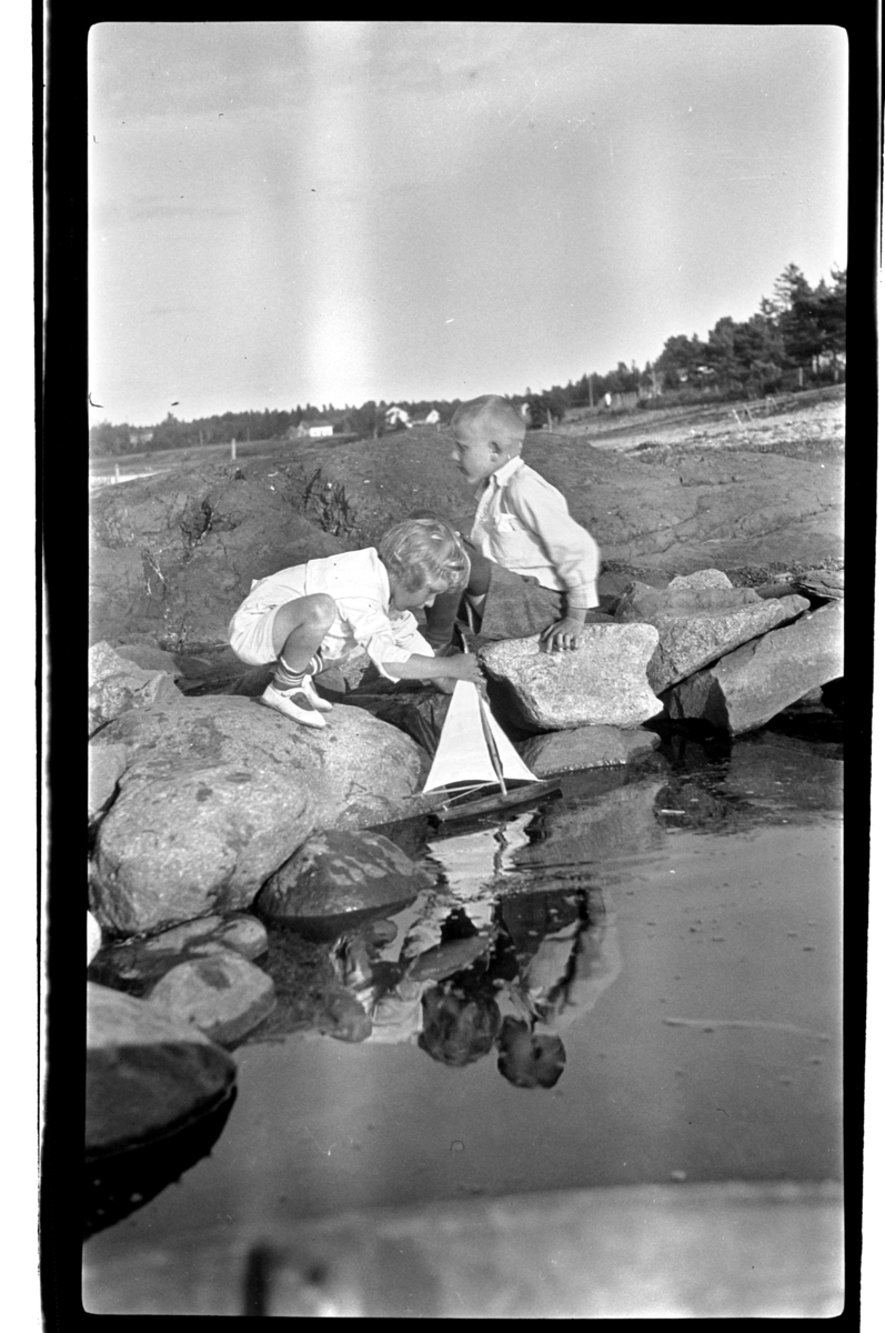 Brødrene Julius og Rolf jr, Sundt leker med seilbåt i fjæra, Slagen. Fotografert 1925.