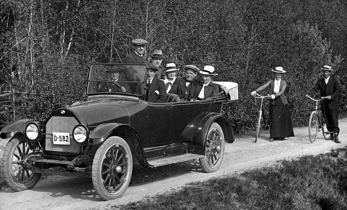 Biltur, søndagstur,utflukt, stående i bilen Sigurd Pedersen "Sig. P" Overland D-582, personbil modell 1917/18. Eier Embret Mellesmo. Syklister