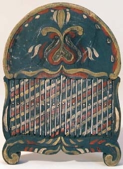 Bandsked av trä. Skeden har bågformigt överstycke varav ena sidan har en utskuren krona och den andra sidan är utsmyckad med kurbitsliknande ornament. Bandskeden är målad i blått, rött, guld och vitt.