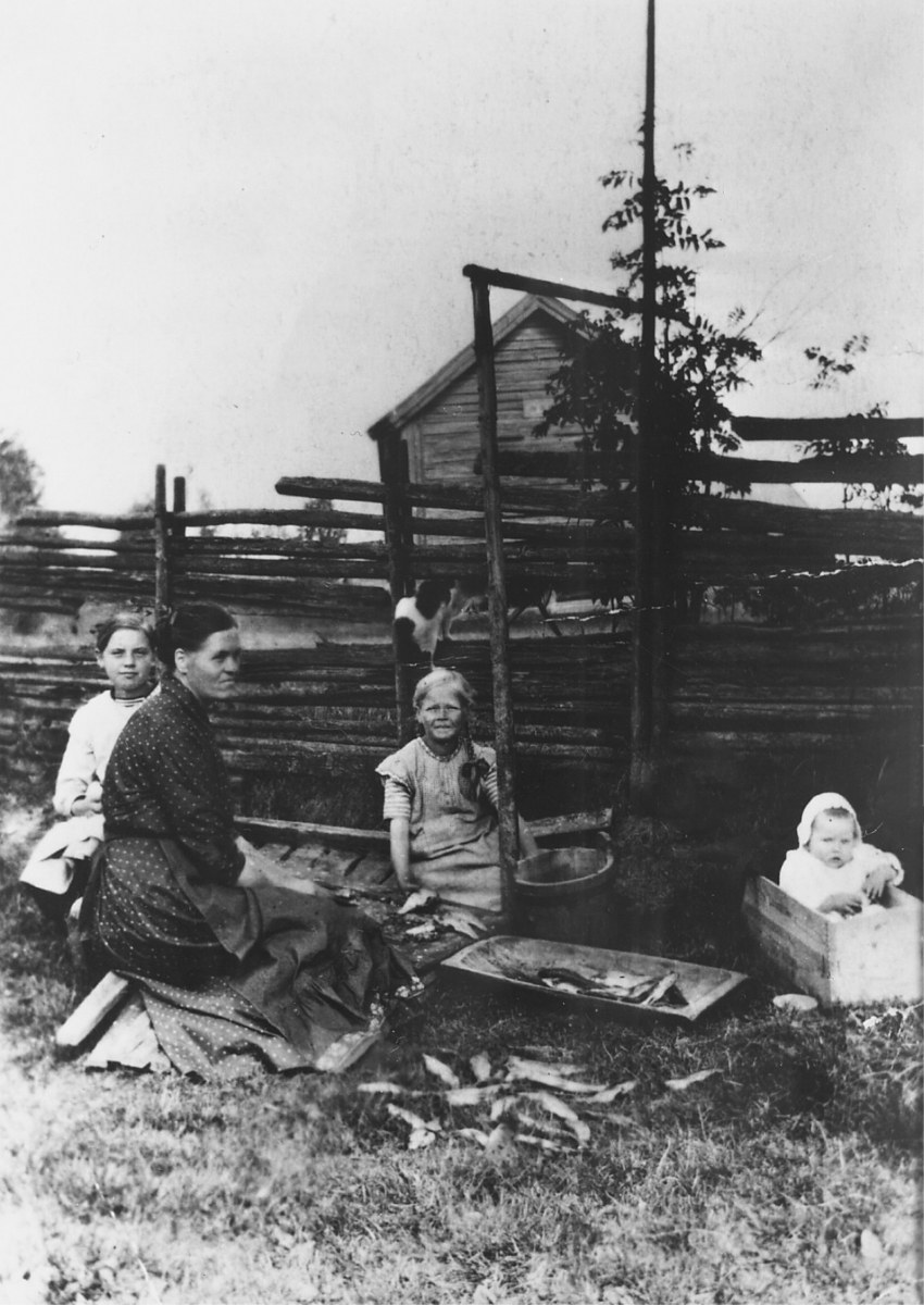 Dette bildet er tatt etter en fisketur ved Sanderenga i Størjebygda omkring 1910. Kari Elstad (født Krogsrud, 1879-1962) sitter sammen med døtrene Oddbjørg og Astrid. Til høyre søsterdattera Signe.