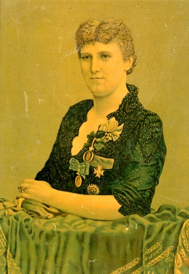Oljetryck.
Porträtt av operasångerskan Christina Nilsson (1843-1921) i svart klänning 
med spetsgarneringar, ordnar och medaljer.