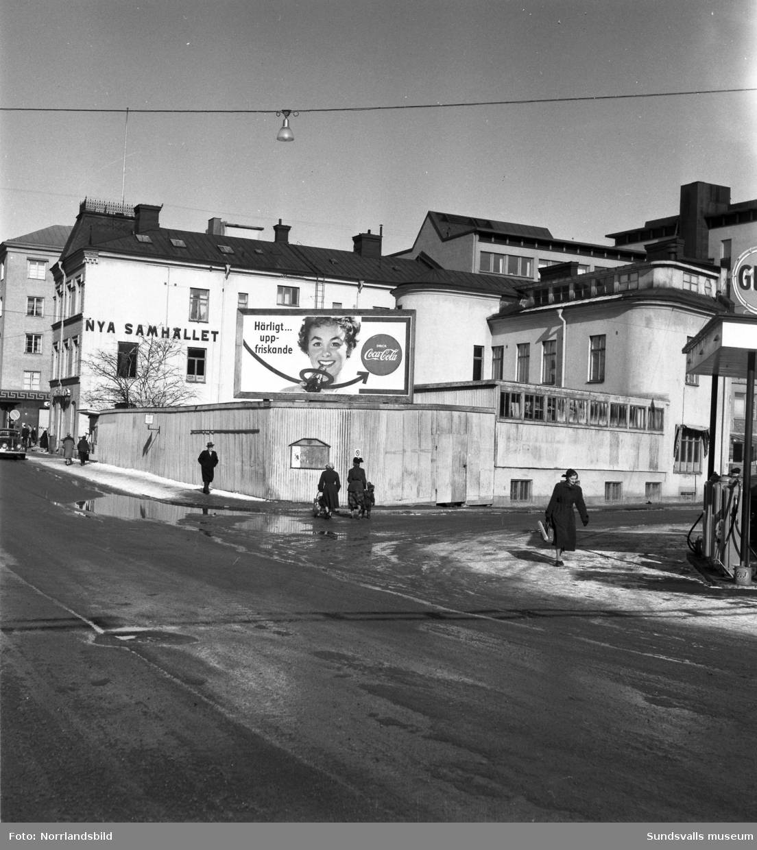 Kvarteret Patronen sett från sydväst, hörnet Nybrogatan-Norra Järnvägsgatan. På planket en stor reklamskylt för Coca Cola.