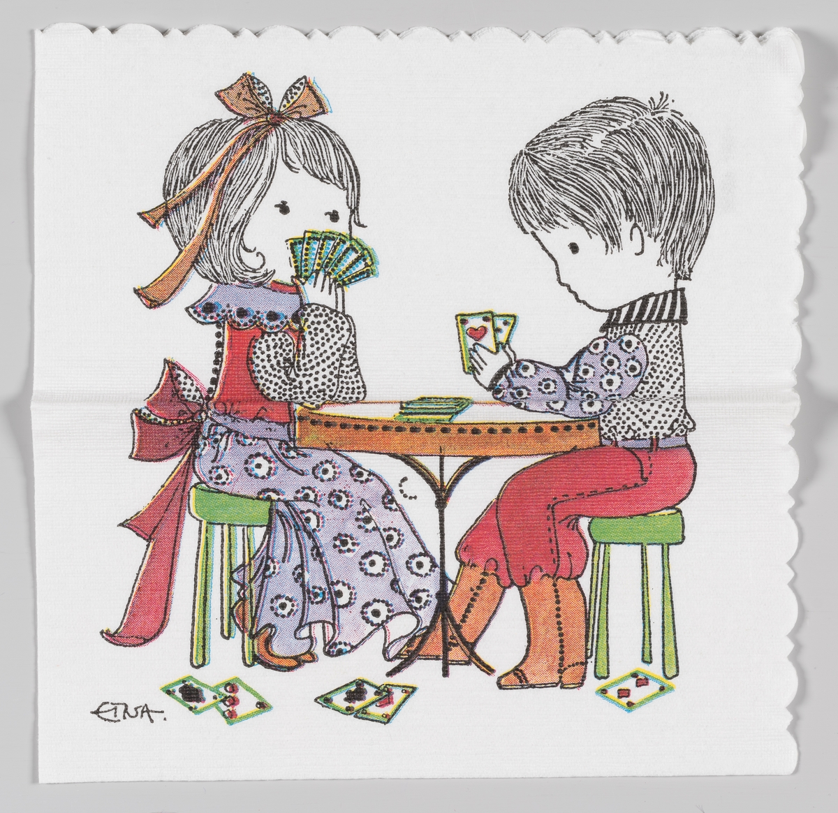 En gutt og en jente spiller kort ved et rundt bord.