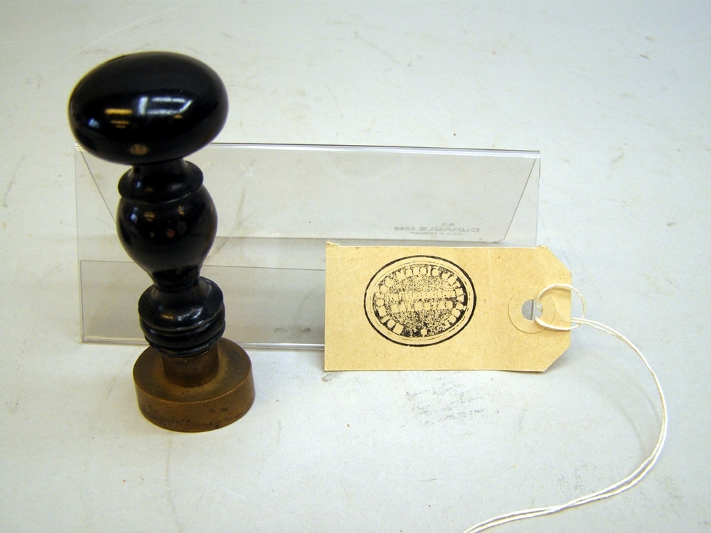 Sigillstämpel med oval stämpelplatta av mässing och svarvat svart träskaft.
HALMSTAD NÄSSJÖ JÄRNVÄGAR Trafik
