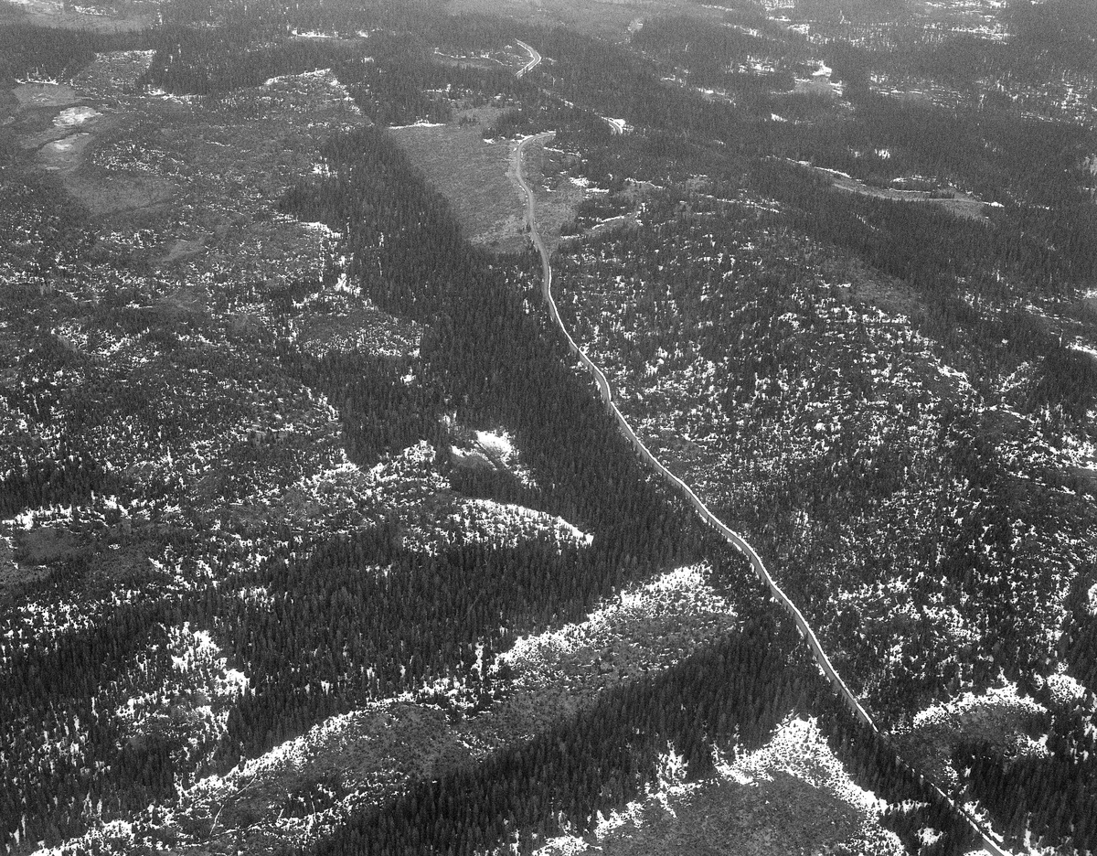Sølnas utløp i Trysilelva. Flyfoto. Bildet ble tatt i midten av mai 1986. Sølna kommer fra nord og renner ut i Trysilelva. På neset ligger det ei koie, og det er en steinforbygning nederst i Sølna.