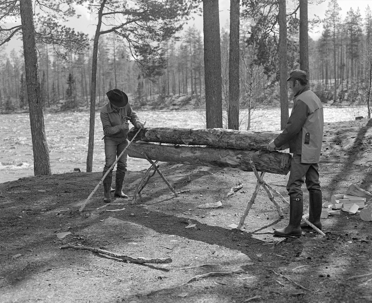 Oppsetting nying ved Stenbekkoia ved Femundselva i Engerdal i mai 1986.  Denne nyingen ble oppsatt og tent som en del av programmet da styret i Klarälvegns Flottningsförening hadde sin ekskursjon langs vassdraget dette året.  Nyinger består av en eller flere horisontalt- og paralleltliggendende stokker, lagt og nørt slik at de skal gi god og vedvarende varme.  Slik ild ble brukt i skog og utmark.  Vinterstid overnattet skogsarbeiderne vanligvis i hus – skogstuer eller koier – med mildt sagt enkel standard.  Men i vårsesongen forekom det ikke sjelden at fløterne sov under åpen himmel og hentet varme og tørk fra nyinger. I en medisinalberetning fra 1871 beskrev distriktslege Christian Pavels Munthe (1816-1884) i Elverum nyingen slik:

«Ikke altid kunne de vaade og forfrosne Flødere finde varmt og beboet Hus til Natten, - ikke engang en Køie, hvor de kunne tørre sine Klæder og finde et varmt Leie.  Meget ofte maa de lægge sig vaade som de ere paa den vaade Jord med et Lag af Barkviste under sig, efterat have opgjort en Ild  - «Nying» - paa følgende Maade: De tage en tyk, letbrændelig Stok, hvorover de lægge en anden noget mindre af samme Slags.  Disse to Stokke holdes fra hinanden ved to eller flere Stykker Træ ved Enderne («Beitkøler»), medens den øverste hindres fra at falde ned ved paa hver Ende at støttes ved tvende længere Kabber, der som Strævere lægges på imod den.  En saadan Kabbe kaldes «Haldmær» og mellem de saaledes ovenpaa hinanden liggende Stokke opgjøres paa flere Steder Ild, der langsomt brænder og underholde Varme den hele Nat.  Fløderne lægge sig nu paa begge Sider af en saadan «Nying», og vende sig gjentagne Gange om Natten, for at snart den ene, snart den anden Side kan blive varmet og tørret ved Ilden.»

Nyingene kunne lages av en eller flere stokker, og var det flere enn to, ble de ofte lagt slik at nyingen fikk et pyramidalt tverrsnitt.  I dette tilfellet var det en to-stokknying, der den underste stokken sto på et trefotet stativ av kjepper.  Oversida av denne stokken og undersida av overstokken var fliset opp ved hjelp av ei øks, og i mellomrommet mellom dem lå det tørre flister, som skulle gjøre det lettere å tenne ildstedet.  Den øverste stokken var støttet med skråstivere av kjepper på begge sider.  Da dette fotografiet ble tatt var arbeidsformann Kåre Joar Graff (til venstre) og en av arbeidskameratene hans i ferd med å den øverste nyingsstokken.  Graff spikret fast ei bjørkeraje som skulle bli «haldmerr».