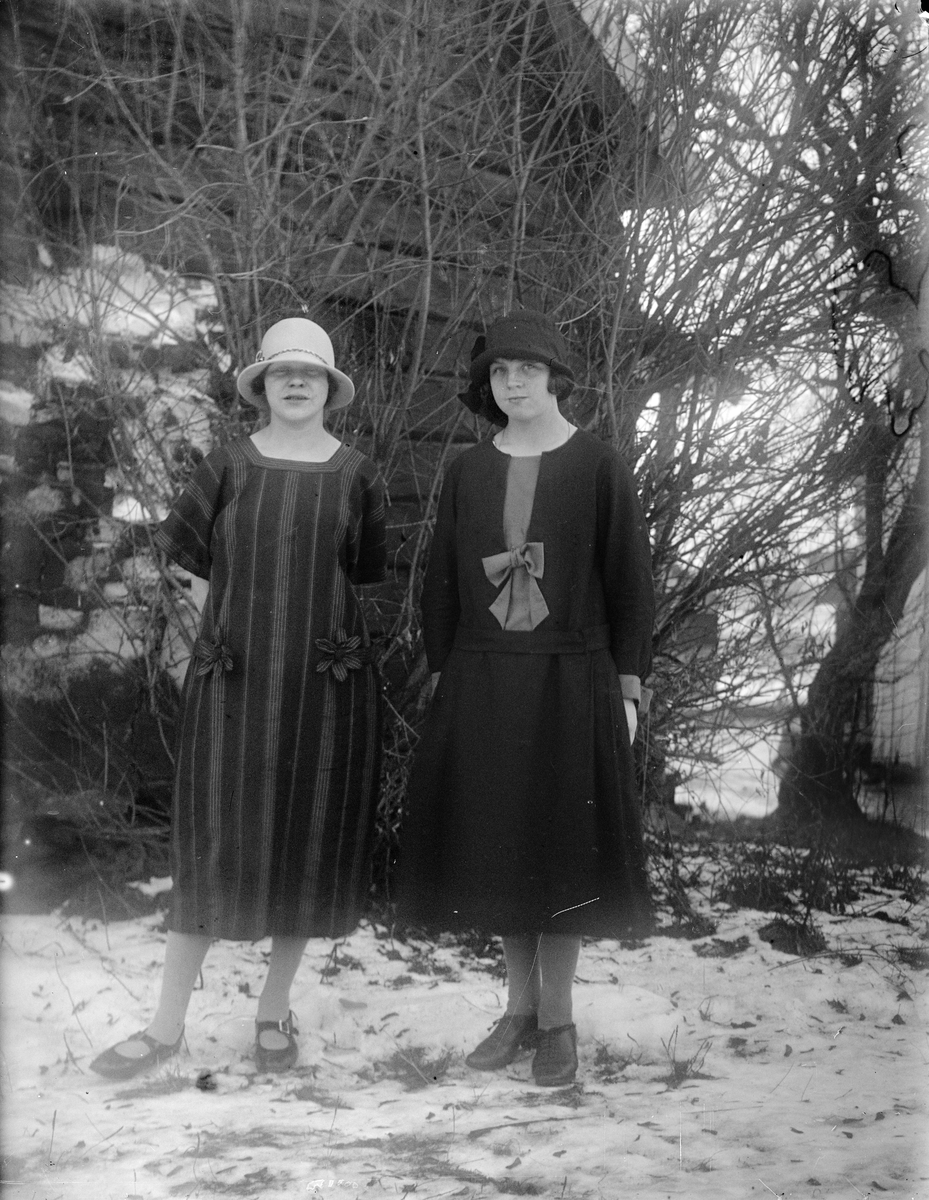 Två unga kvinnor framför husgavel, Uppland