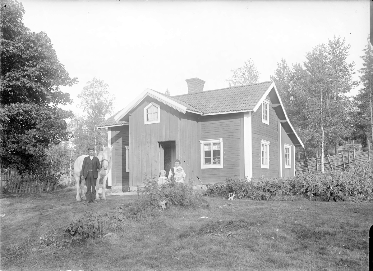 Familjen Åhlén framför nybyggartorpet Nybo, Smedsbo 1:5, Tärna socken, Uppland, sannolikt sommaren 1915