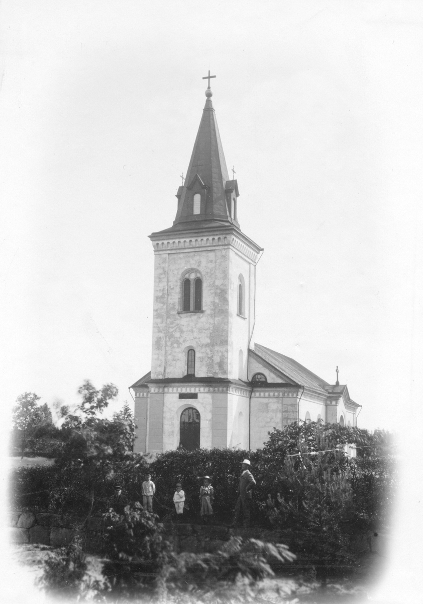 Hångers kyrka uppförd år 1881. Till höger står kantor Alfred Ericsson med vit hatt tillsammans med en äldre man och tre barn.