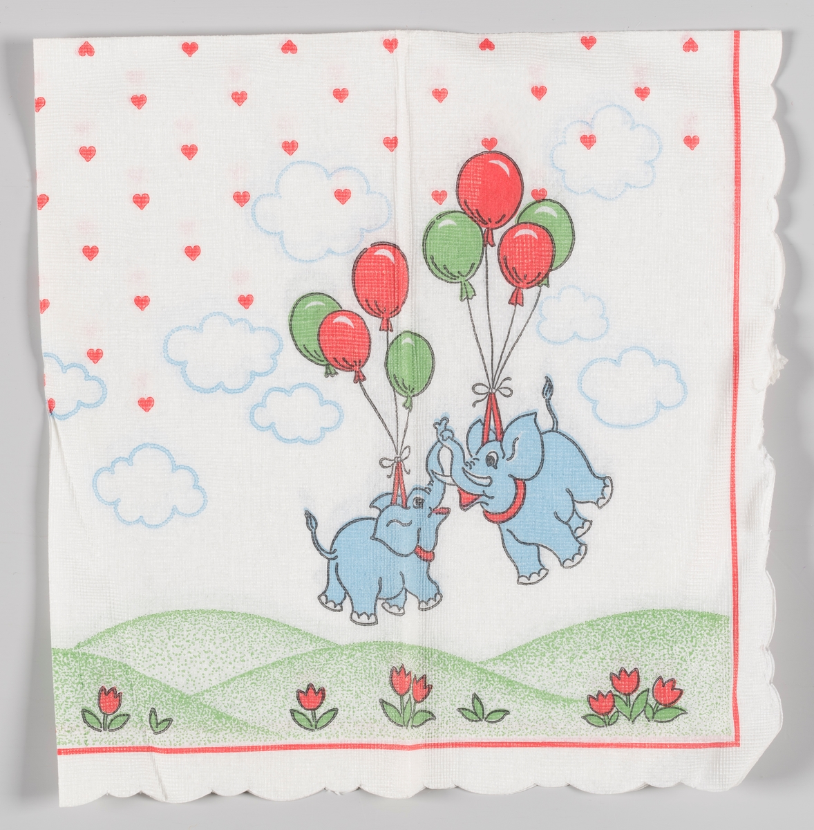 To flygende elefanter som holdes opp i luften av ballonger. Bakkelandskap og blomster. Hjerter og skyer på himmelen.