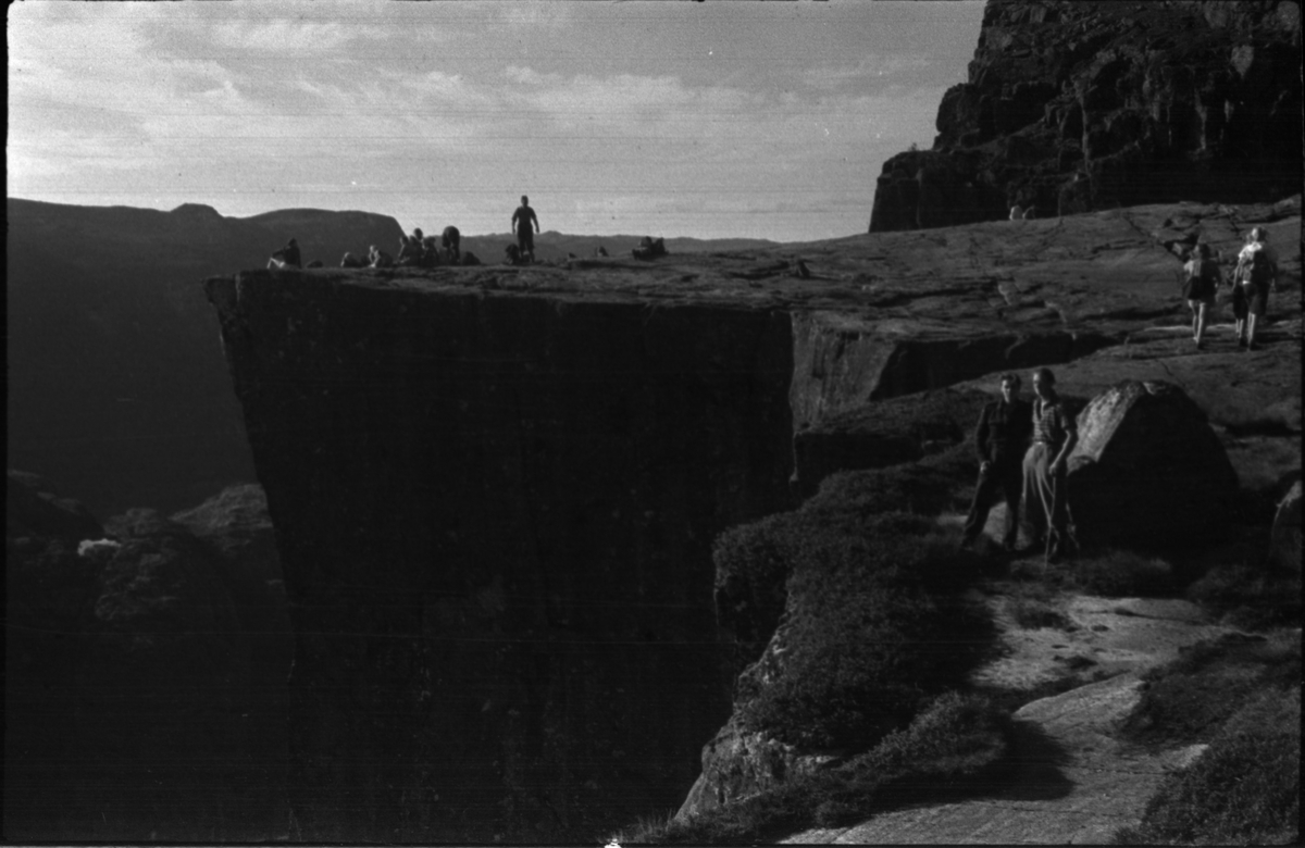 Anton Birkemo og en mann under kallenavn "Skotten" på tur mellom Preikestolen og Bratteli ved Lysefjorden. Det er bilder av fjellformasjonser som Hyvletomma (?), Preikestolen, Hengjafjell og Hengjanibbene, og turister som besøker Preikestolen og Hengjafjell.