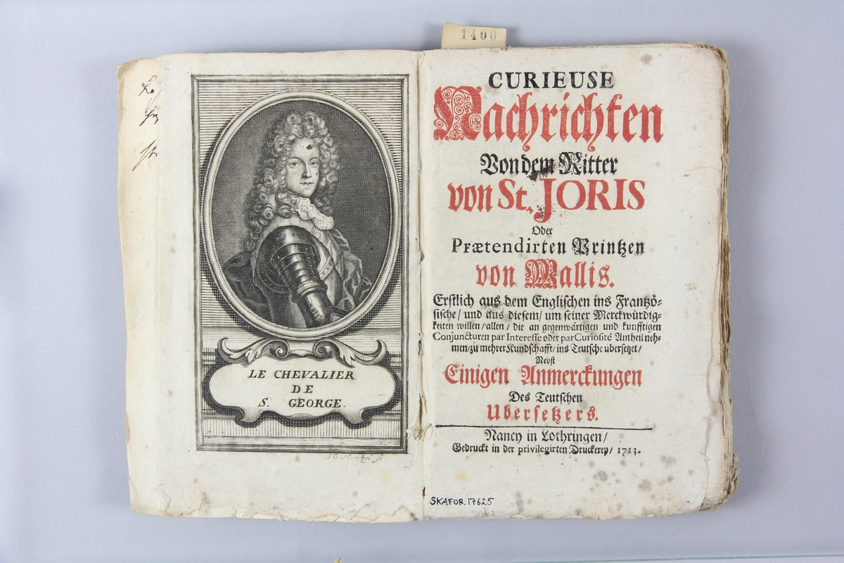 Bok, pappband, "Curieuse Nachrichten von dem Ritter von St. Joris", tryckt 1713 i Nancy
Pärm av marmorerat papper, oskuret snitt. Blekt rygg med pappersetikett med volymens namn och samlingsnummer. Anteckning om inköp på pärmens insida.