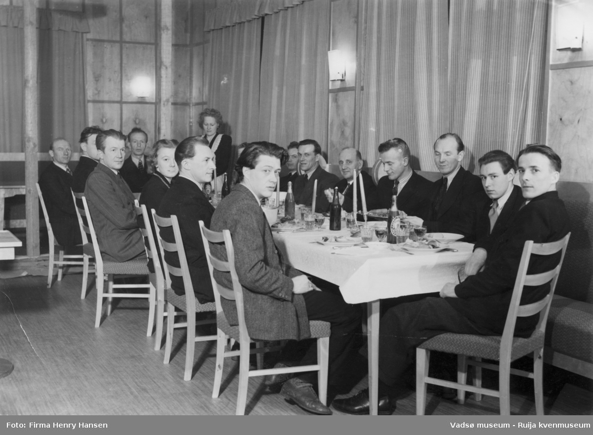 Menn og noen kvinner samlet rundt et festbord. Bjørn Sanness, Nils Fr. Jørgensen, Wara.G., Melsvik, Ingvald Ofstad, Bergljot Isaksen. Kilde; tekst bak på bildet (247_2)