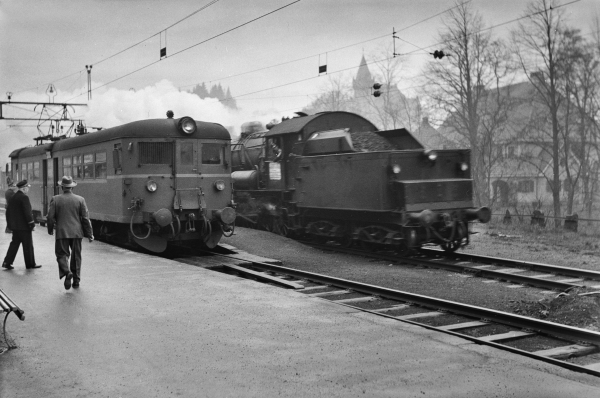 Kryssing på Fjøsanger stasjon mellomllokaltog reting Voss, tog 624, og godstog til Bergen, tog 5501. Godstoget trekkes av damplokomotiv type 33a nr. 300. I lokaltoget elektrisk motorvogn Bmeo 65.