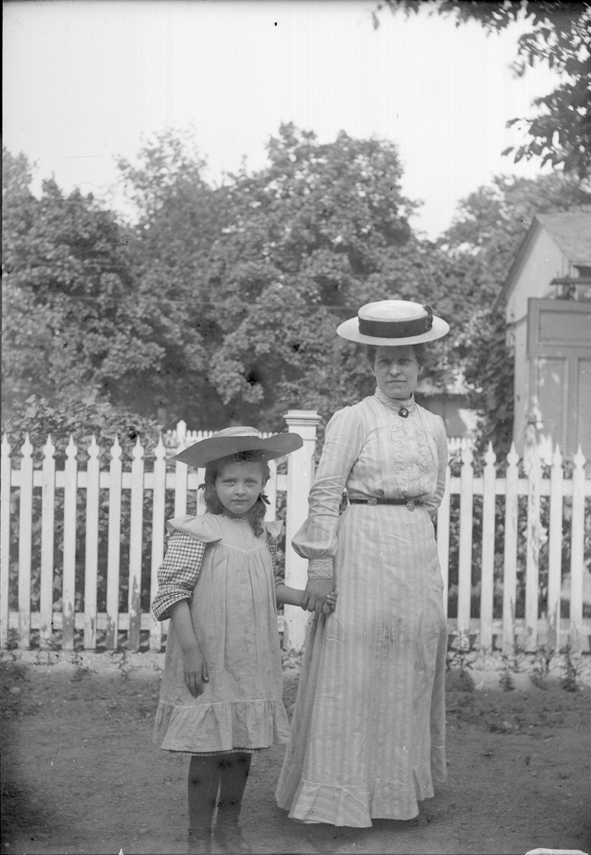 Emma Osti och flicka på gården utanför ateljén på Bredgränd 11, Uppsala före 1914