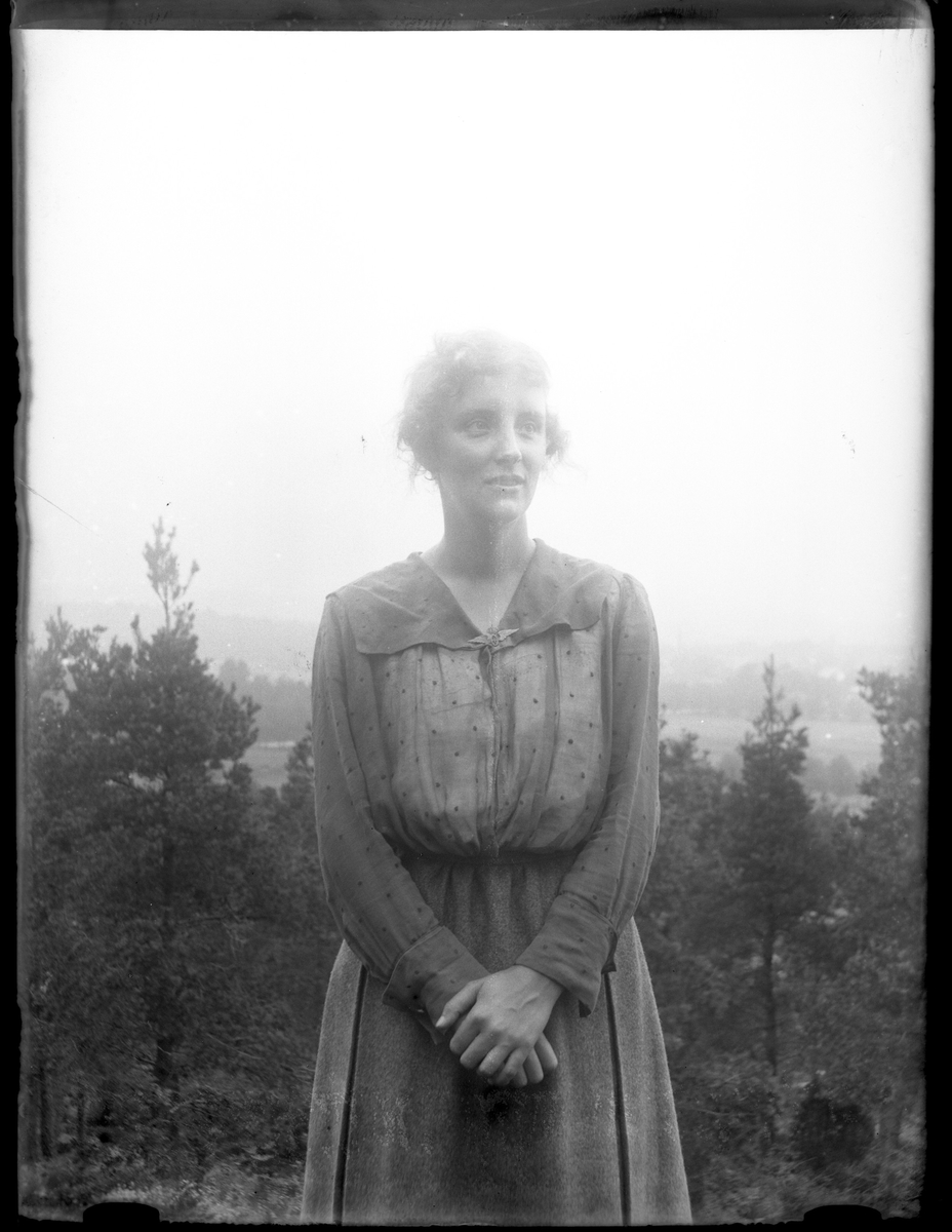 Porträtt av Ellen Andersson med händerna knäppta framför sig.
