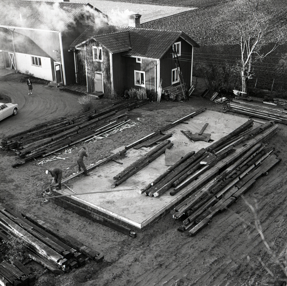 Husgrunden till ett nytt bostadshus vid gården Sunnanåker omgiven av timmerstockar, 1967.