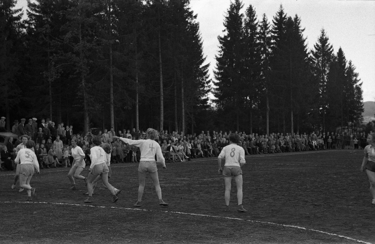 Håndballkamp på Kraby Idrettsplass september 1953. Kampen var kvartfinale i damenes Norgesmesterskap mot Nornen fra Bergen, en kamp Kraby vant og dermed kvlifiserte seg for semifinale. Krabys spillere, i de mørkeste buksene, er identifisert, men for navn henvises til lagbilde TMF-06483.
14 bilder som viser kampsituasjoner og publikum.