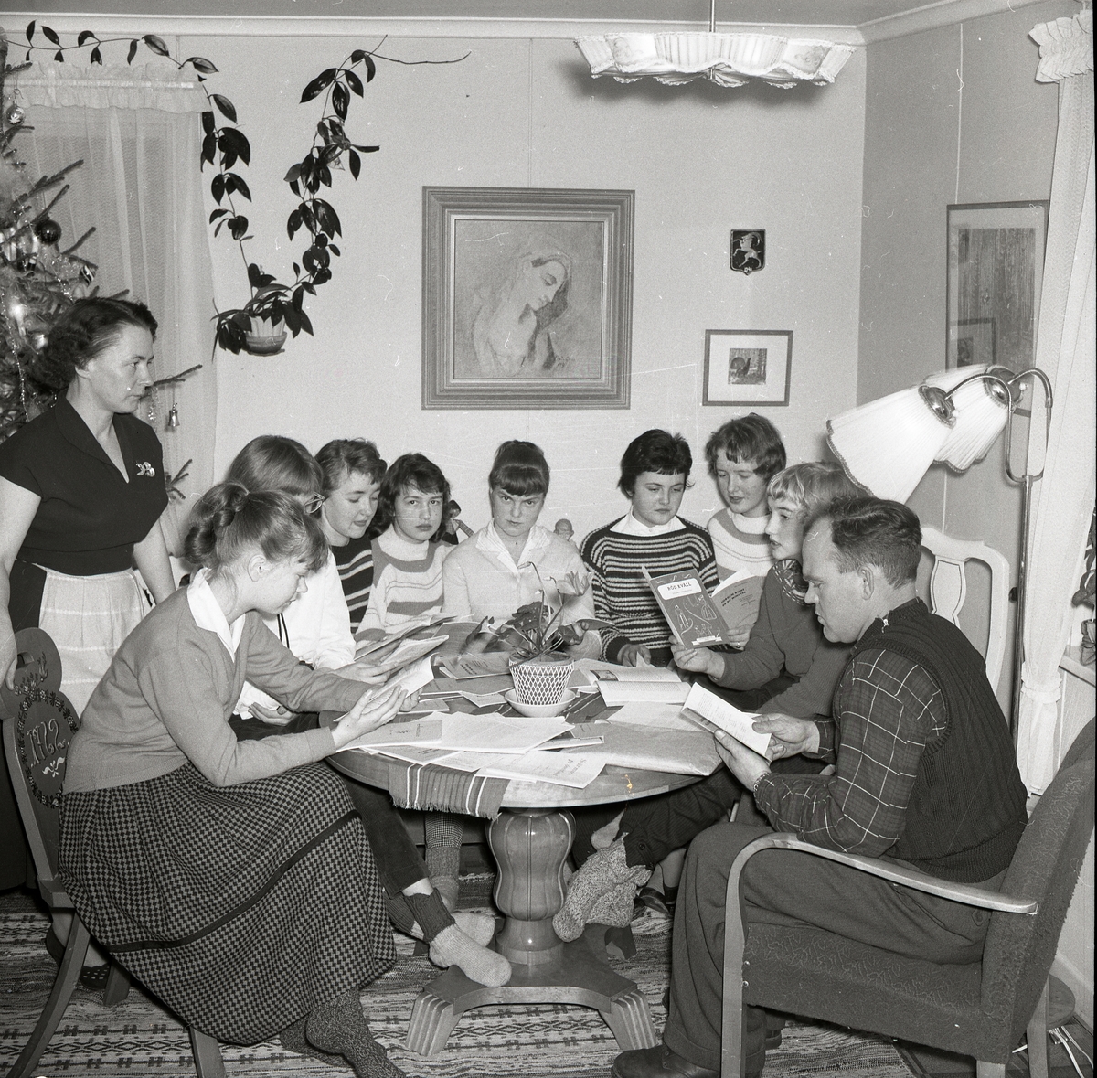 En grupp vuxna och ungdomar deltar i en studiecirkel hemma hos Hilding och Adéle, 19 januari 1958.