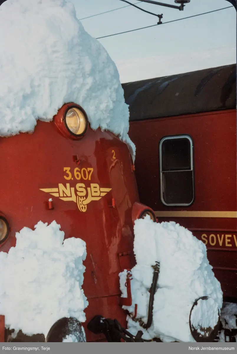 Nattoget fra Bergen til Oslo, tog 606, kjørte seg fast i snøen ved Oksebotn km 295, mellom Finse og Haugastøl. Toget ble trukket av diesellokomotiv type Di 3 nr. 607 og elektrisk lokomotiv type El 14 nr. 2188. Her er materiellet hentet tilbake til Finse stasjon.