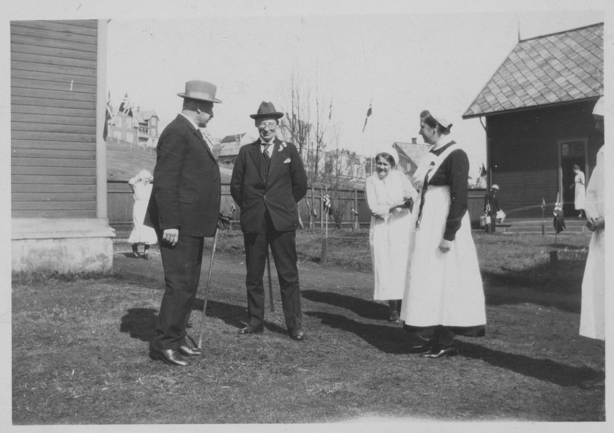 To menn og flere sykesøstre utenfor gamle Harstad sykehus.