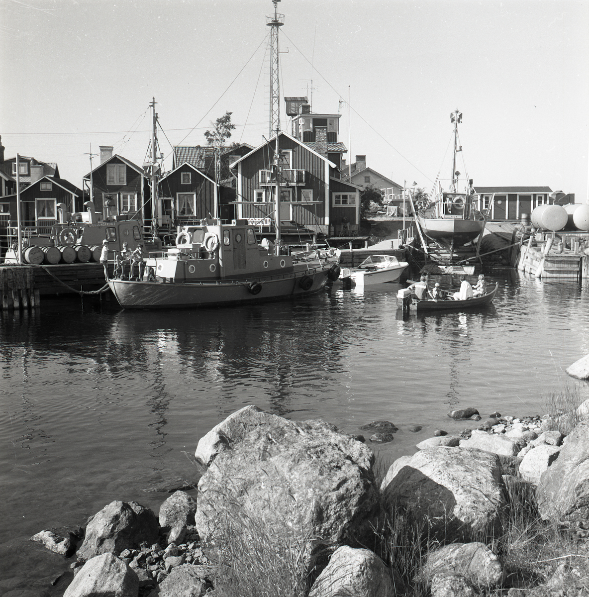 Båthamn i Söderhamn med stora och små båtar, i bakgrunden syns några hus.