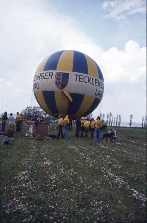 Ballongfestival 1973 i Gränna. Gasballongen Tecklenburger Land, omgiven av folk, görs färdig för att lyfta. Ballongkorgen står intill. Diabild.