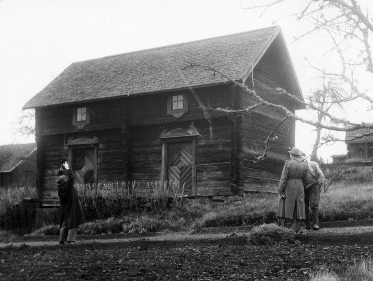 En man fotograferar ett hus i Ökna, Vetlanda kommun.