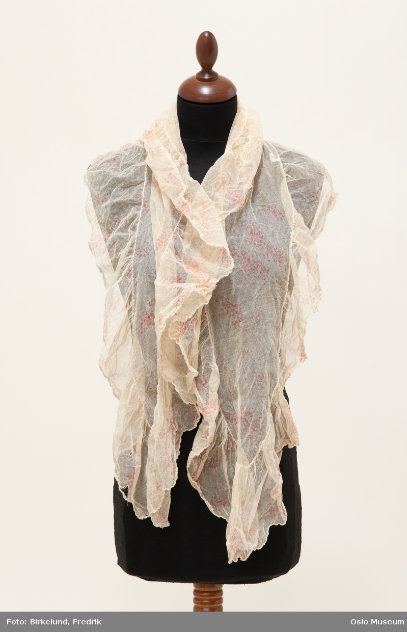 Ecrufarget sjal i tyll med rosa trykket mønster. Sydde rysjer langs kanten.