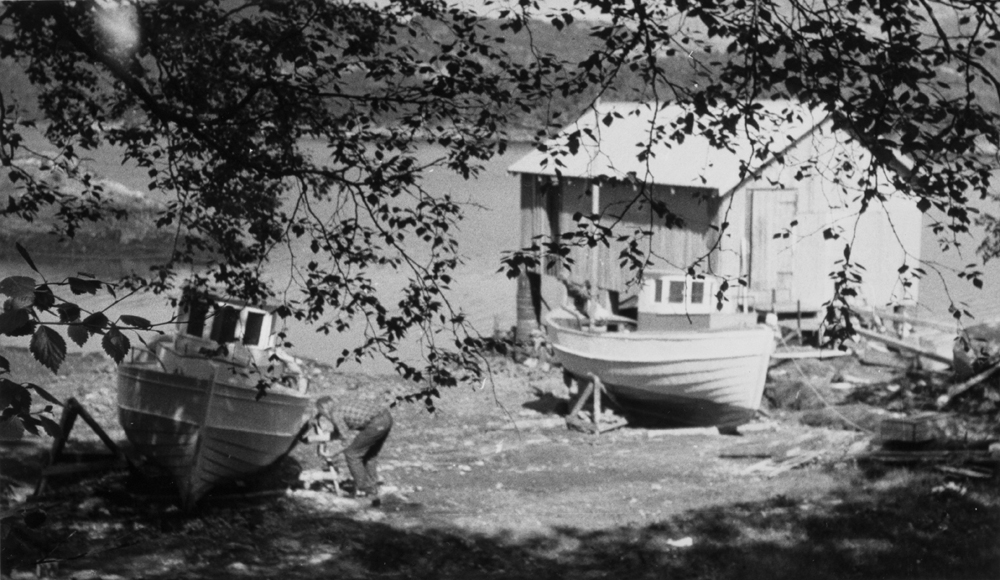 Båtpuss i Halsfjorden, sjark, naust, mann som pusser båt.
