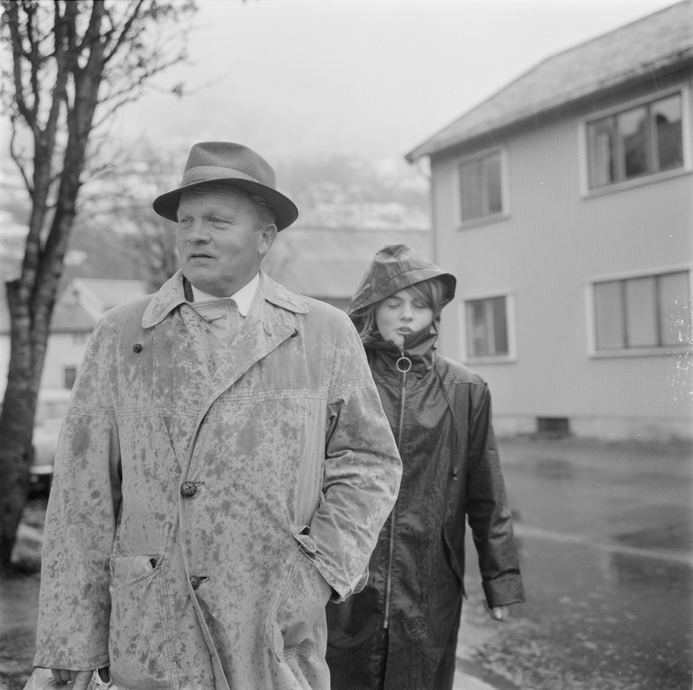 Tiendebyttet 1966. Mann og ung kvinne ute i regnet.