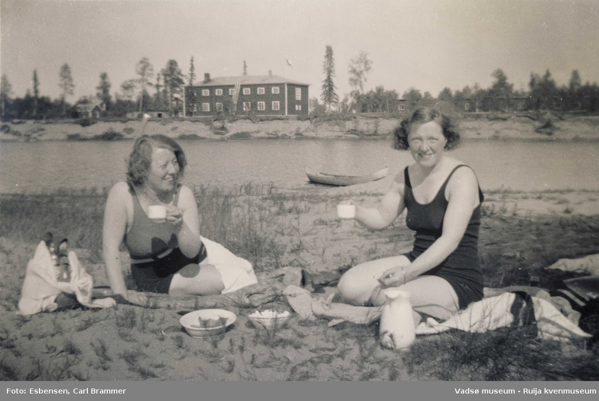 Gunvor Moe og Dagny Engelsen på stranda på ferie i 1935. I bakgrunn hotellet i Ivalo. 