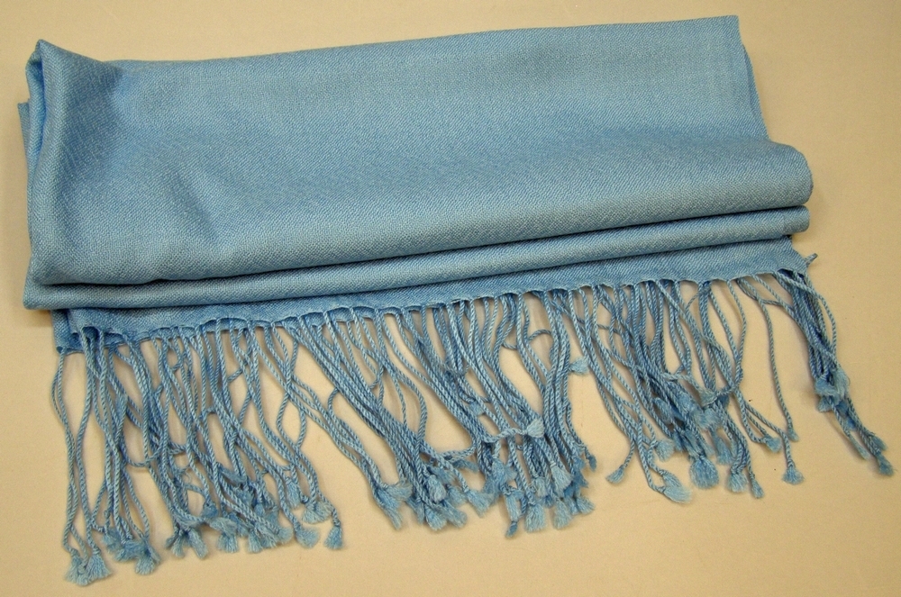 Rektangulär scarf av silke och bomull, ljusblå med långa fransar. Med Botniabanan AB:s logotyp i ett av hörnen.
I originalförpackning av papper, svart med designermärkning.