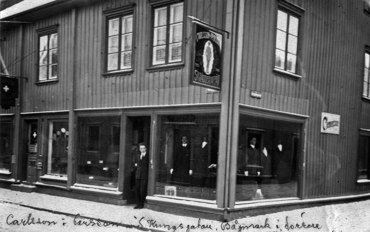 Carlsson & Perssons skrädderiaffär i hörnet av Kungsgatan och Färgaregatan, kvarteret Friden. På fotografiet står anteckningen "Carlsson o Persson vid Kungsgatan, Bågmark i dörren"