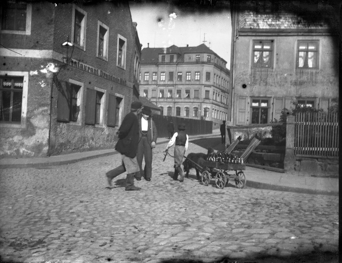 By miljø, ukjent sted. Skilt til venstre: Restaurant Drødnder (?). Muligens en hund som sleper vogn med drikke

Antatt fotosamling etter Anders Johnsen.