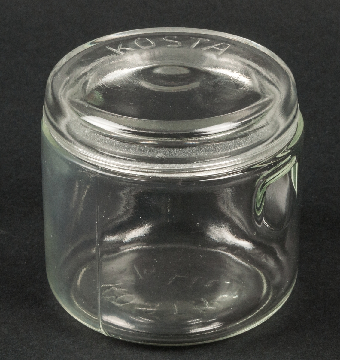 Tre konserveringsglas med lock. 1/4 liter.
Glas. 2 fördjupningar upptill på sidan. På undersidan märkt "KOSTA 1/4 Lit"