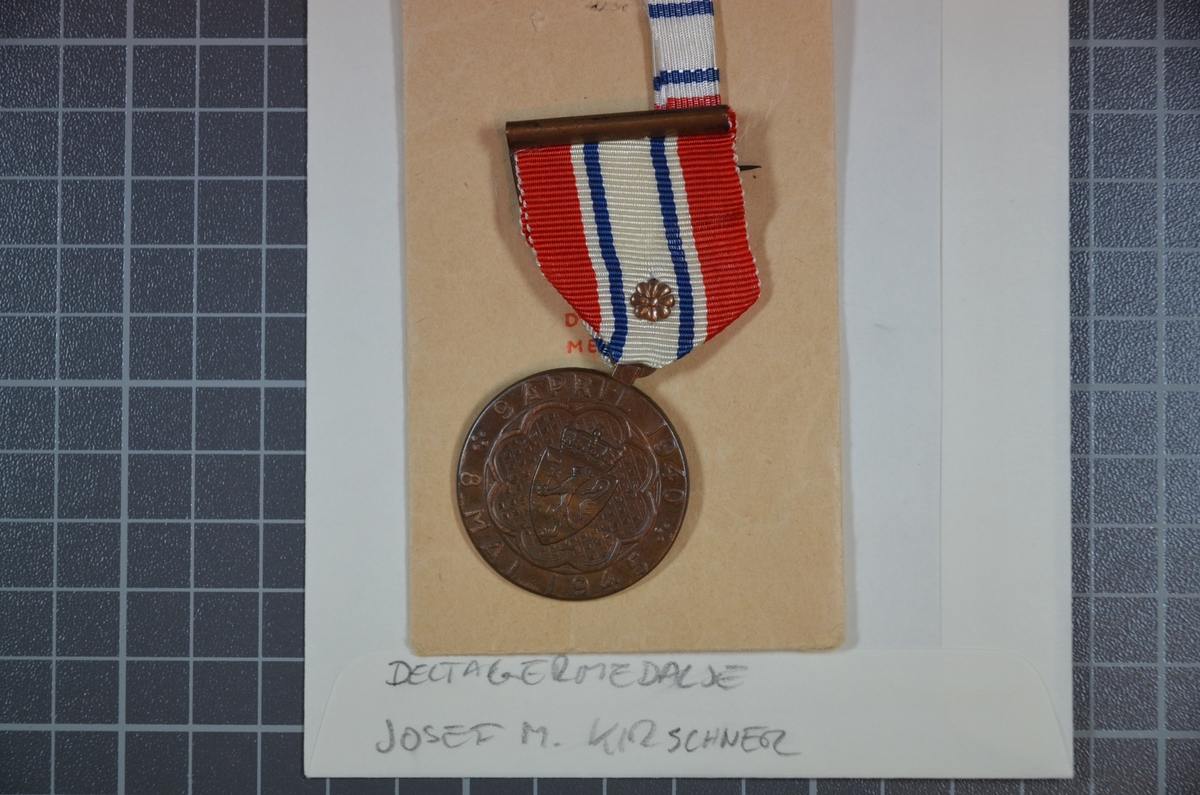 Deltagermedaljen er i original tildelingspose med ordensbånd som bæres når medaljen ikke bæres.