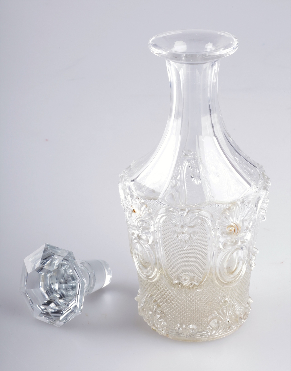 Karaffel i pressglass, med slipt hals og propp. Samme mønster som glasset nr EKM-10258.