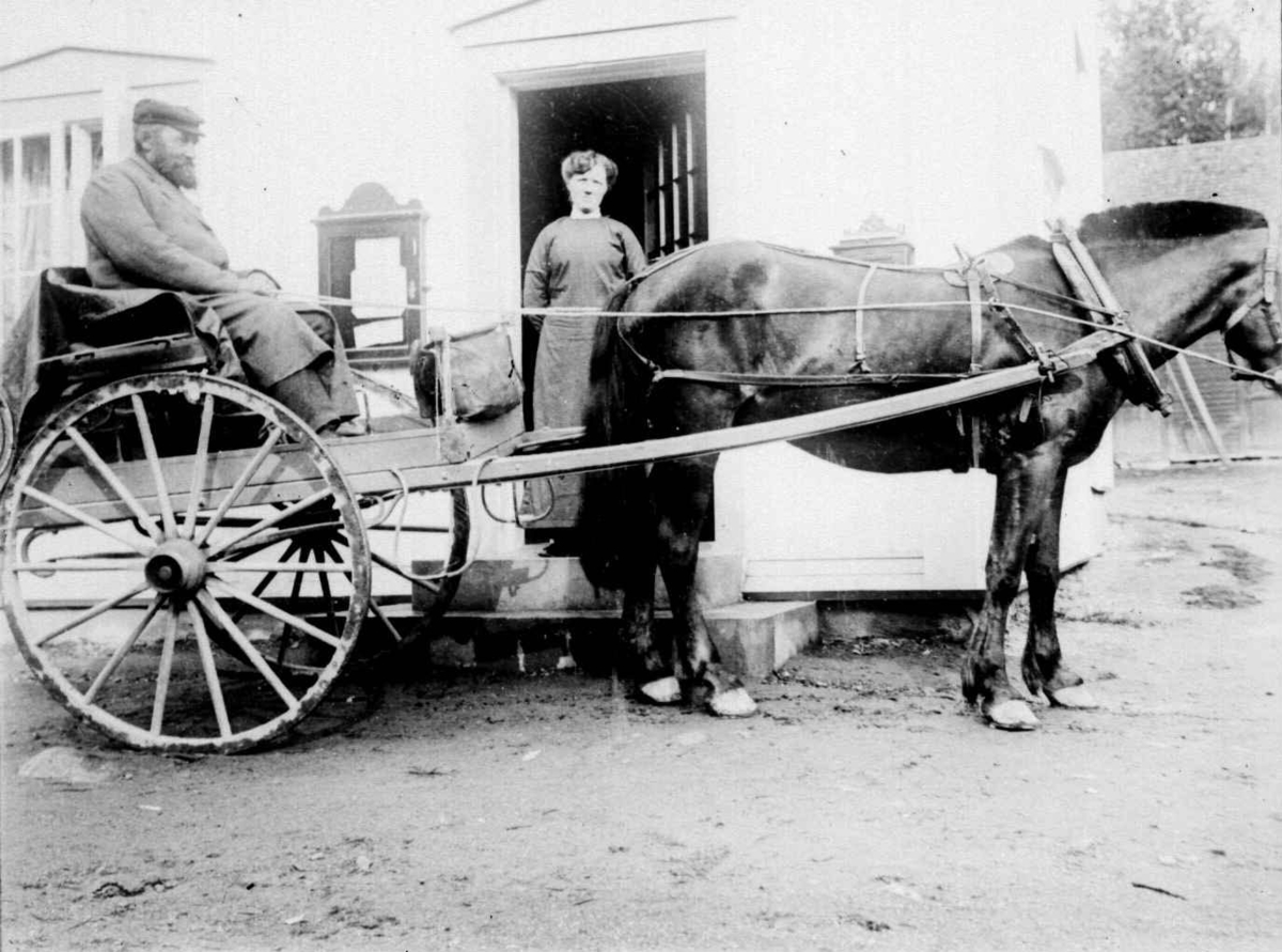 Postmann Andersen i hest og kjerre utenfor antatt butikk med oppslagstavle
