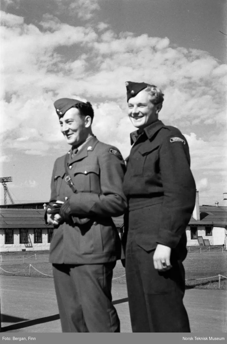 Gruppebilde, to smilende personer i uniform