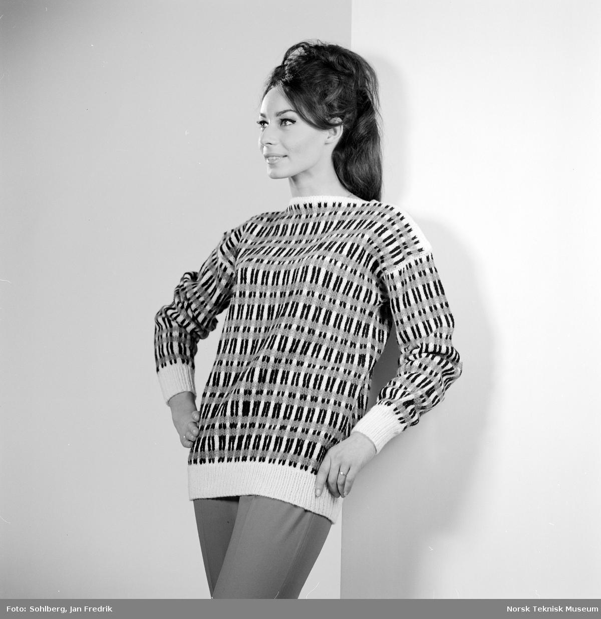 Kvinnelig modell i strikket genser. Fra Norsk Dameblad v/ Laila Retland, februar 1964.