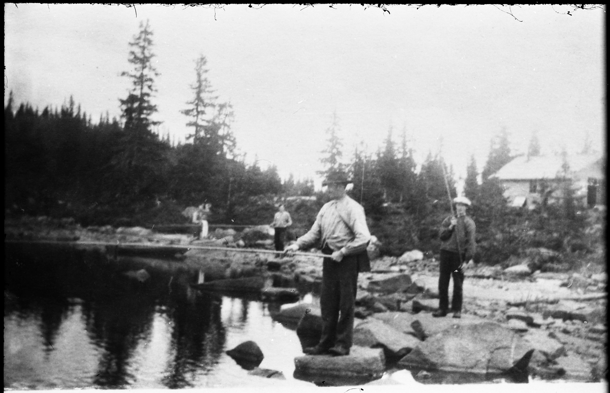 Avfotografert bilde av noen menn som fisker i et tjern. Hverken personer eller sted er identifisert.