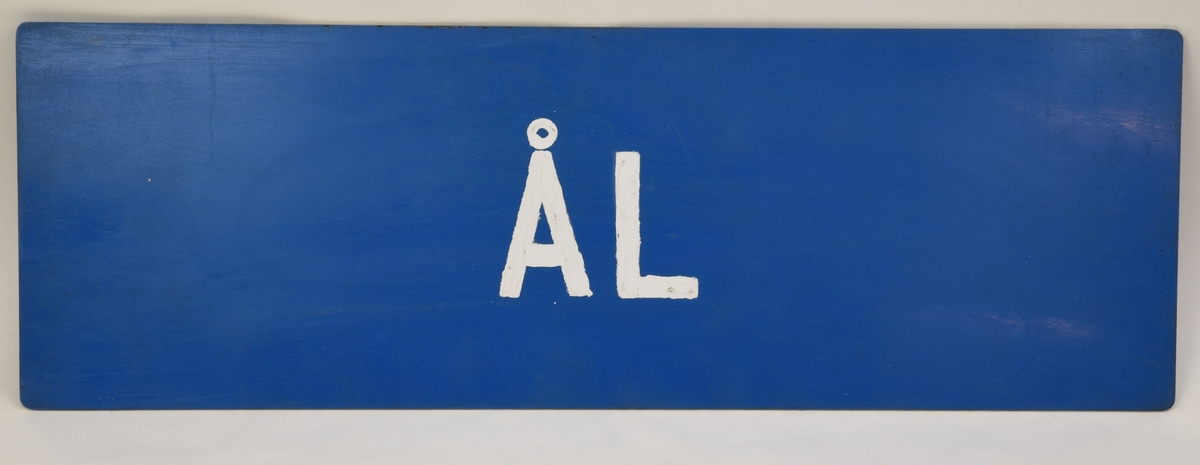 En blå dubbelsidig skylt med den vita handmålade texten "ÅL" på båda sidor.
