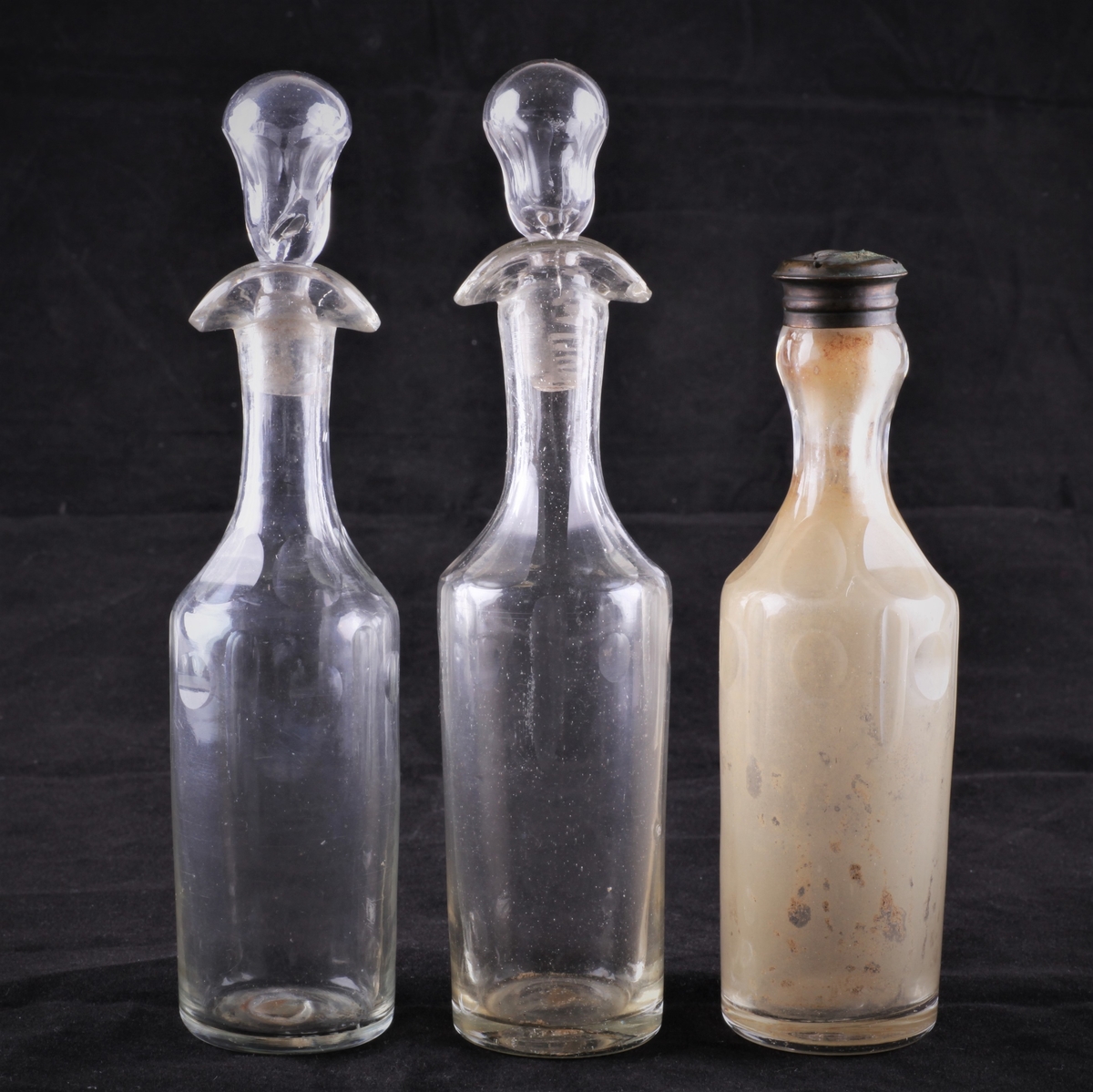 Flasken er slank med dobbel helletut og glasspropp. Den er dekorert med fassettsliping og olivensliping i annethvert felt øverst på kroppen.