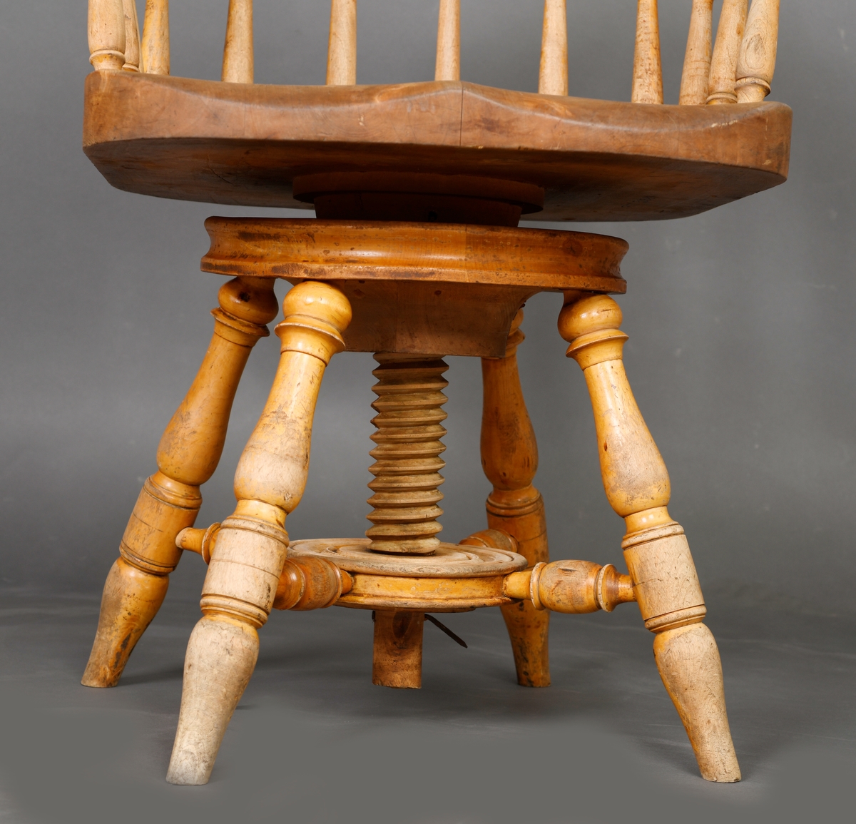 En stol med dreibart sete og armlener. Stolen er laget av heltre og har treforbindelser. Setet er bredt og dypt. Ryggen består av av 12 spiler/pinner som har enkel dreid dekor. Disse er festet i setet og i en bue som er øverst. Stolen har fire bein som står skrått ut fra midten på stolen. Midt under er det en konstruksjon som gjør at stolen er dreibar og kan justeres i høyden.